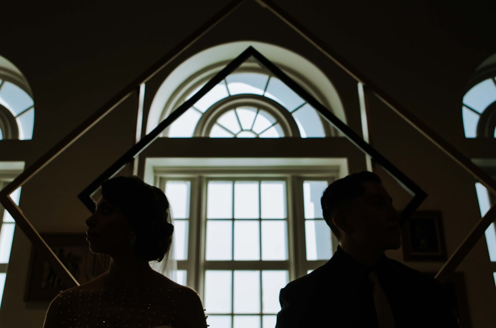 man and woman standing near window