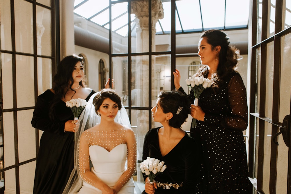 Femme en robe blanche sans manches tenant un bouquet de fleurs