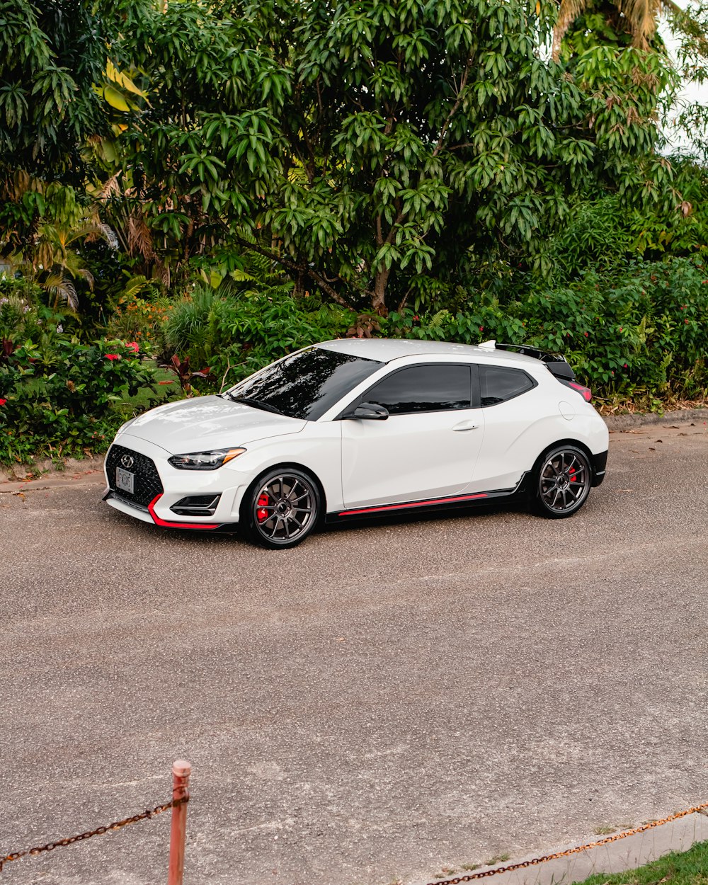 white coupe parked on gray concrete road