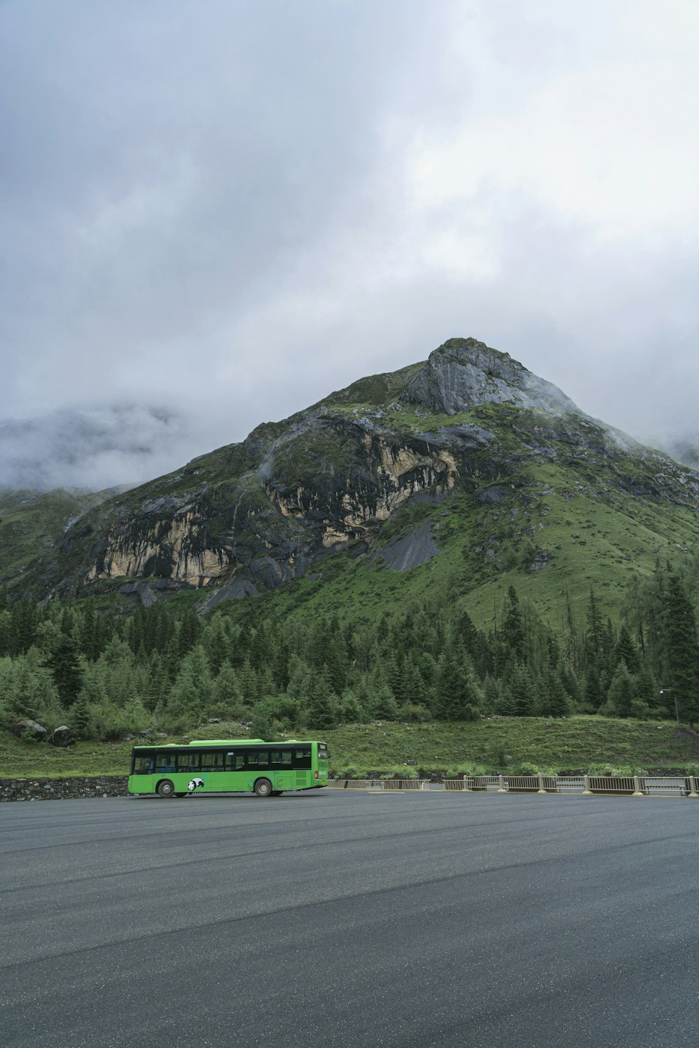 caminhão verde na estrada perto da montanha durante o dia