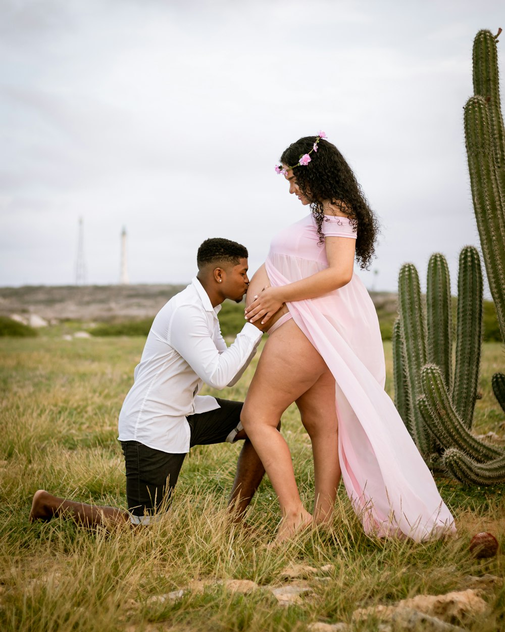 man and woman kissing on grass field during daytime