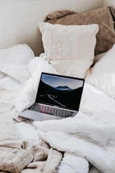 macbook pro on white bed