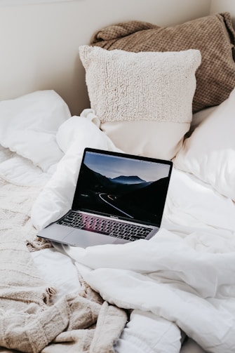 macbook pro on white bed