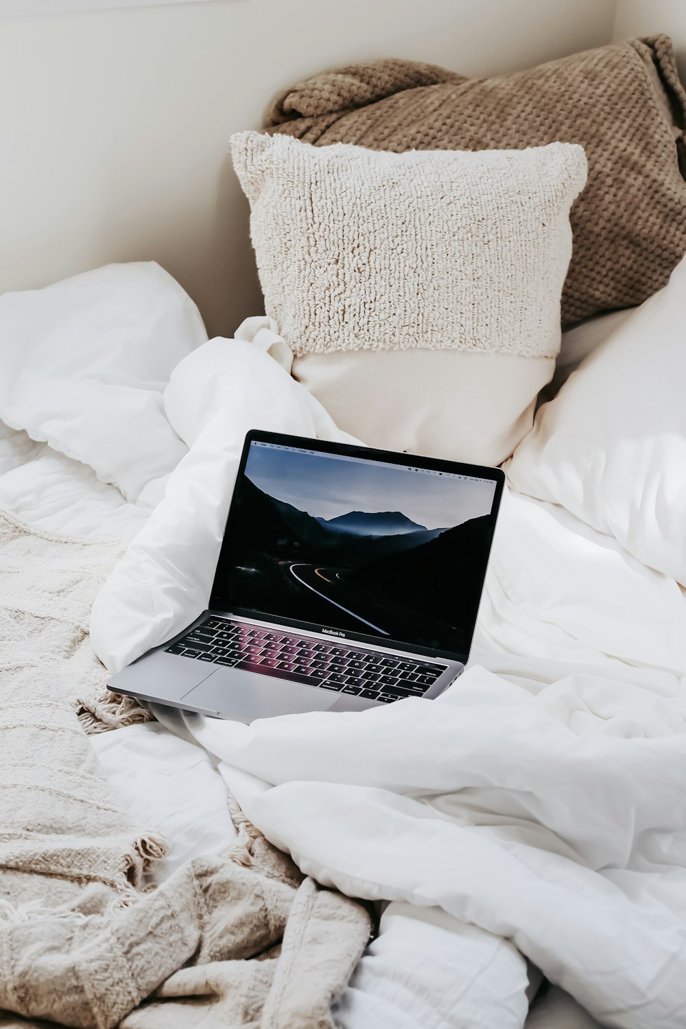 MacBook Pro sur lit blanc