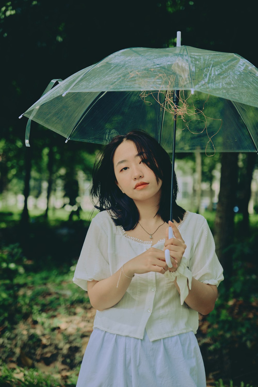 Mujer en vestido blanco sosteniendo paraguas