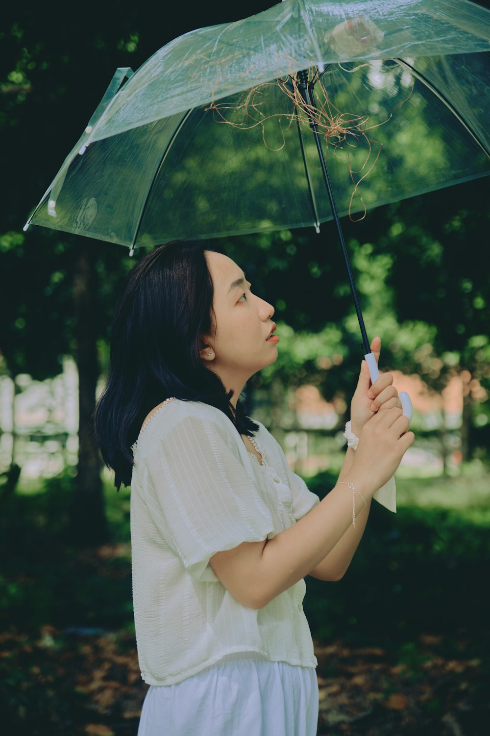 Mujer con camisa blanca sosteniendo paraguas
