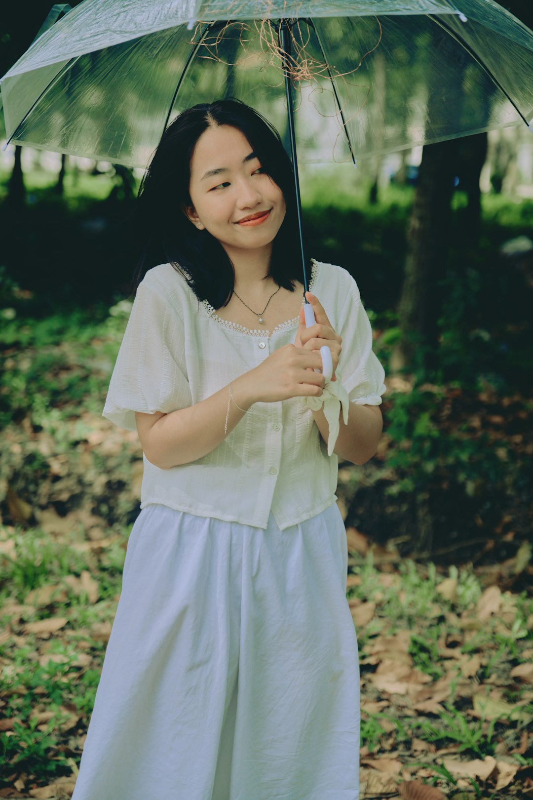 woman in white dress holding umbrella