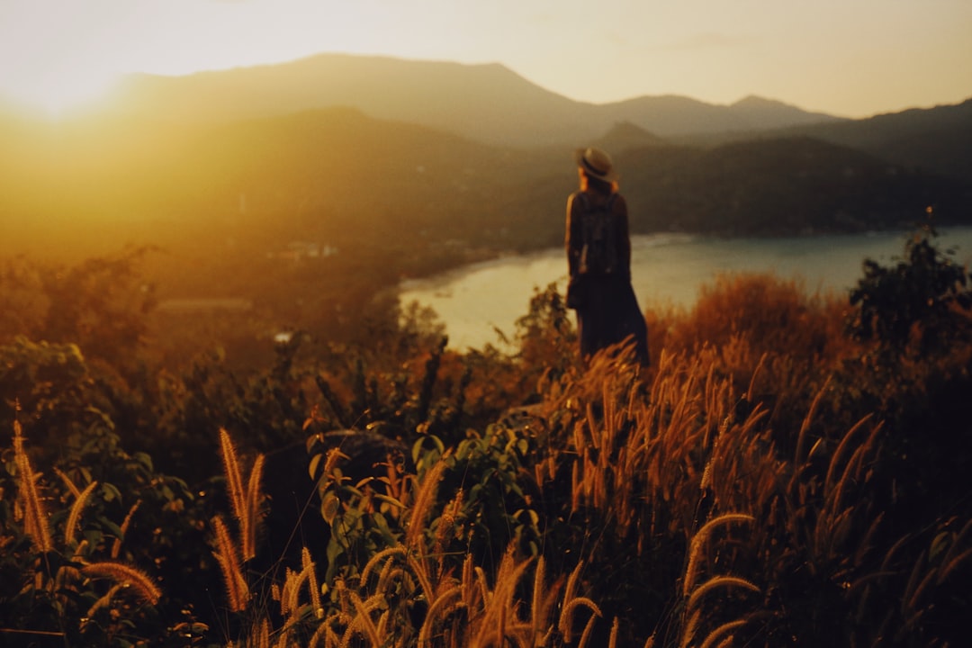 woman in black dress standing on brown grass field during daytime