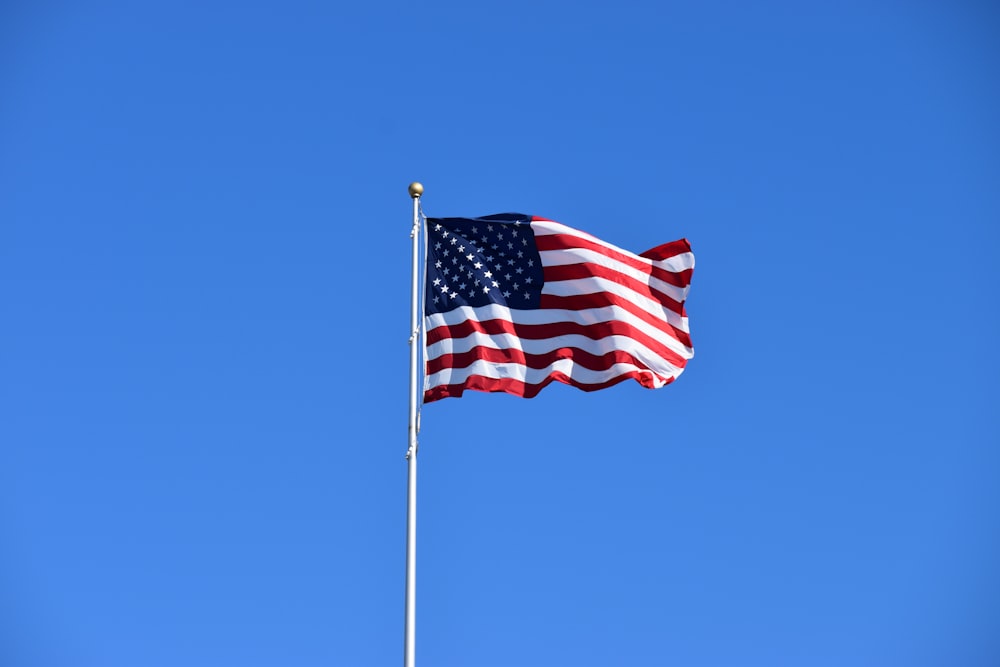 us a flag on pole during daytime