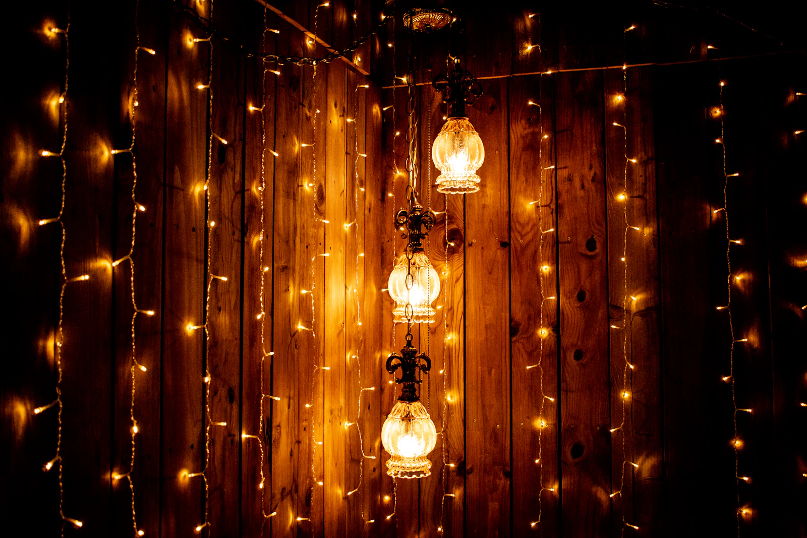 Warm pendant lamps hanging low, throwing brown and amber light.