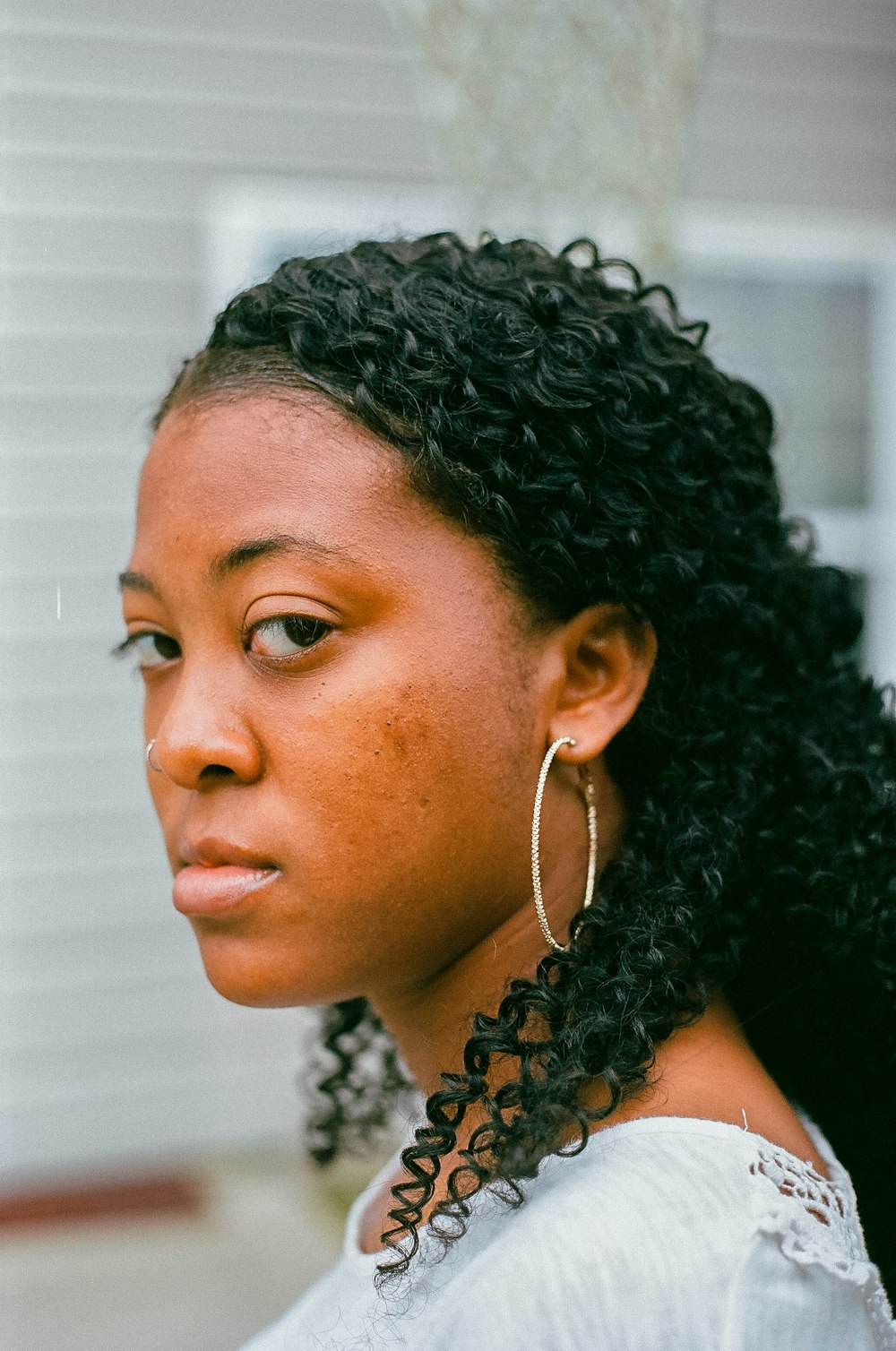 woman in black and white polka dot shirt wearing gold hoop earrings