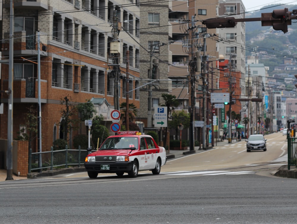 red and white car on road near building during daytime