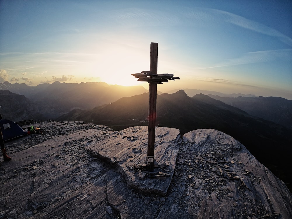brown cross on top of mountain during daytime