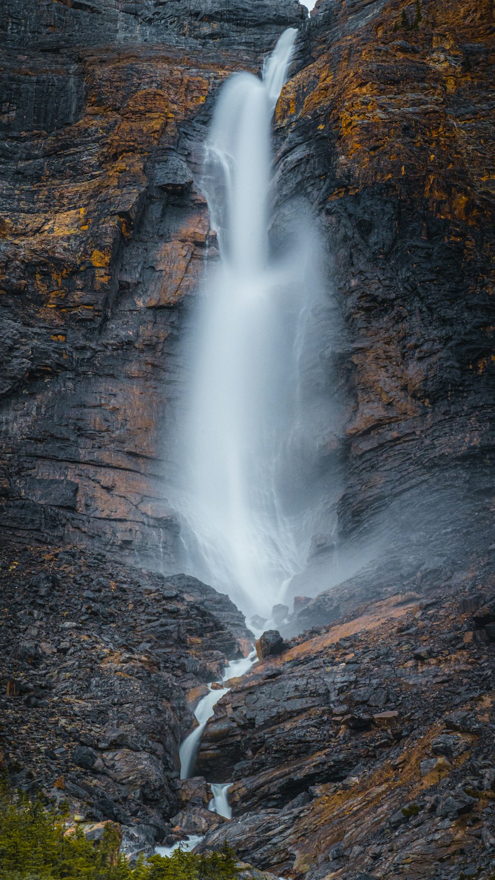 water falls on brown rocky mountain