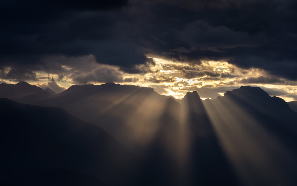 silhouette of mountains under cloudy sky during daytime