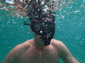 man in black goggles under water