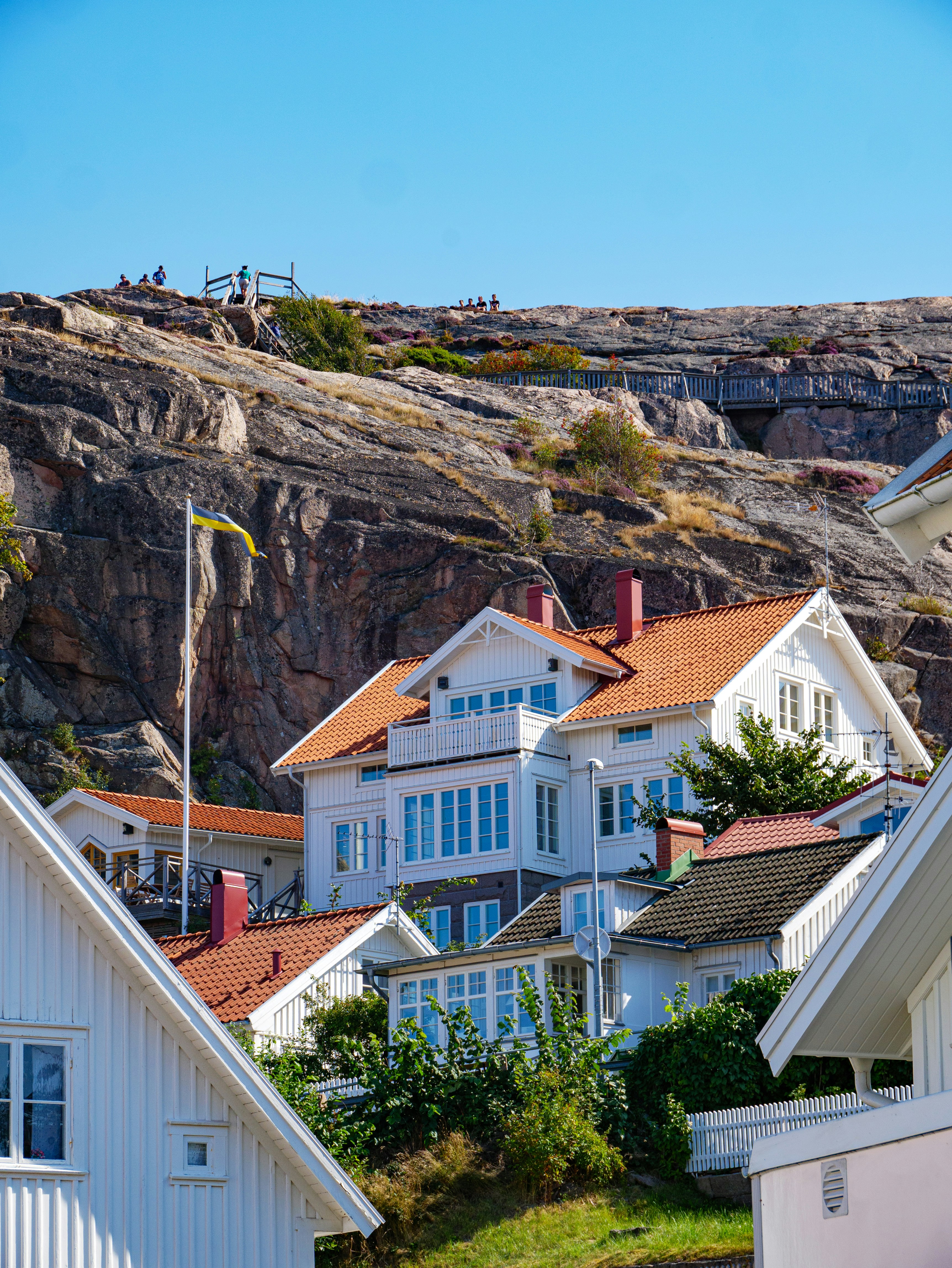 white and brown concrete house near brown mountain under blue sky during daytime
