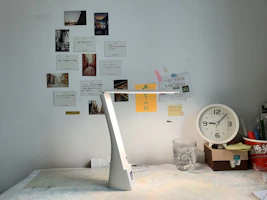 Organized desktop accessories including notebooks, pens, and a lamp