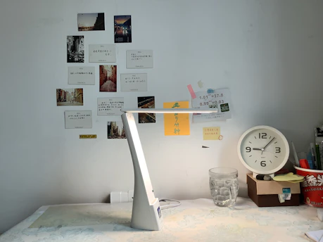 Organized desktop accessories including notebooks, pens, and a lamp
