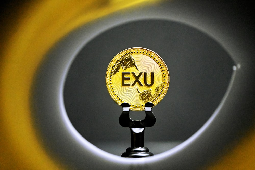 a close up of a gold plate with the word exu on it