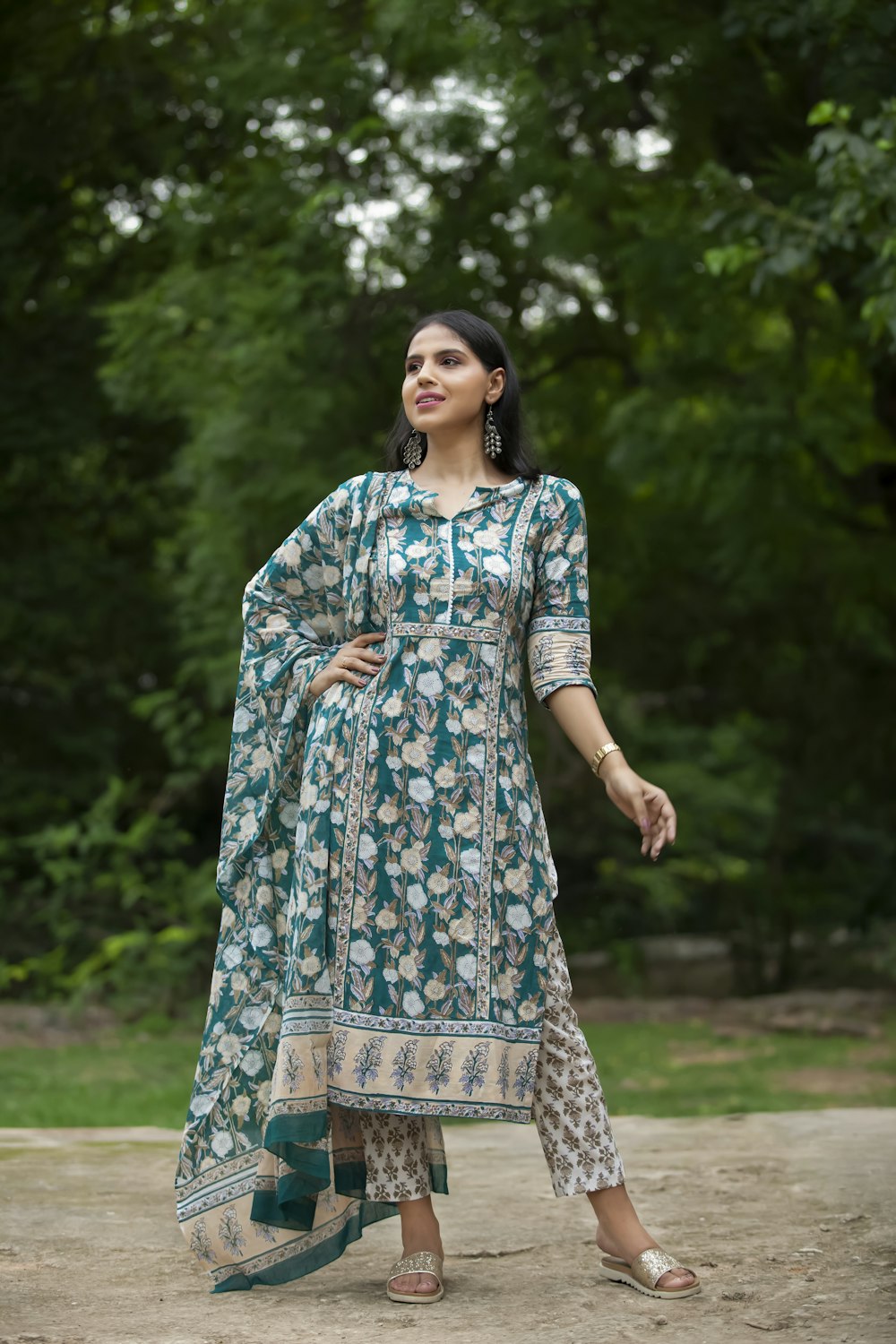 woman in blue and white floral dress standing on green grass field during daytime