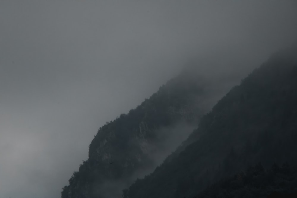 montaña negra cubierta por niebla blanca