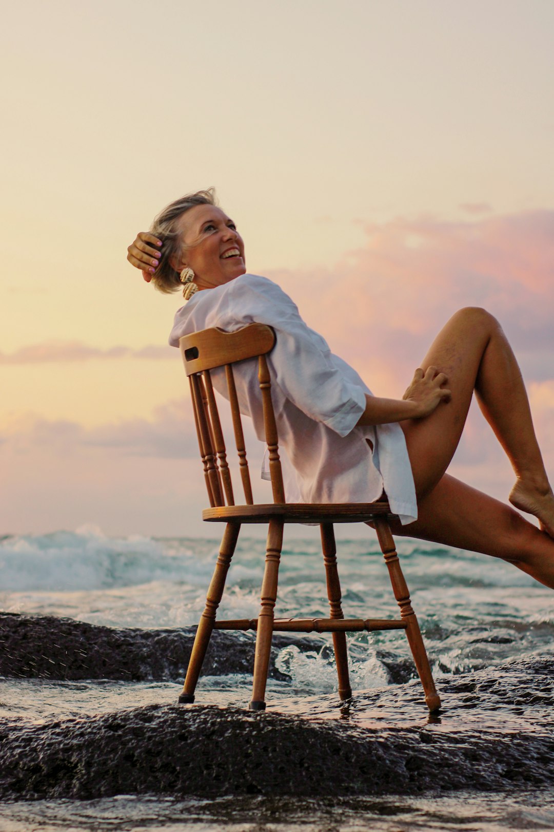 woman in white towel sitting on brown wooden chair