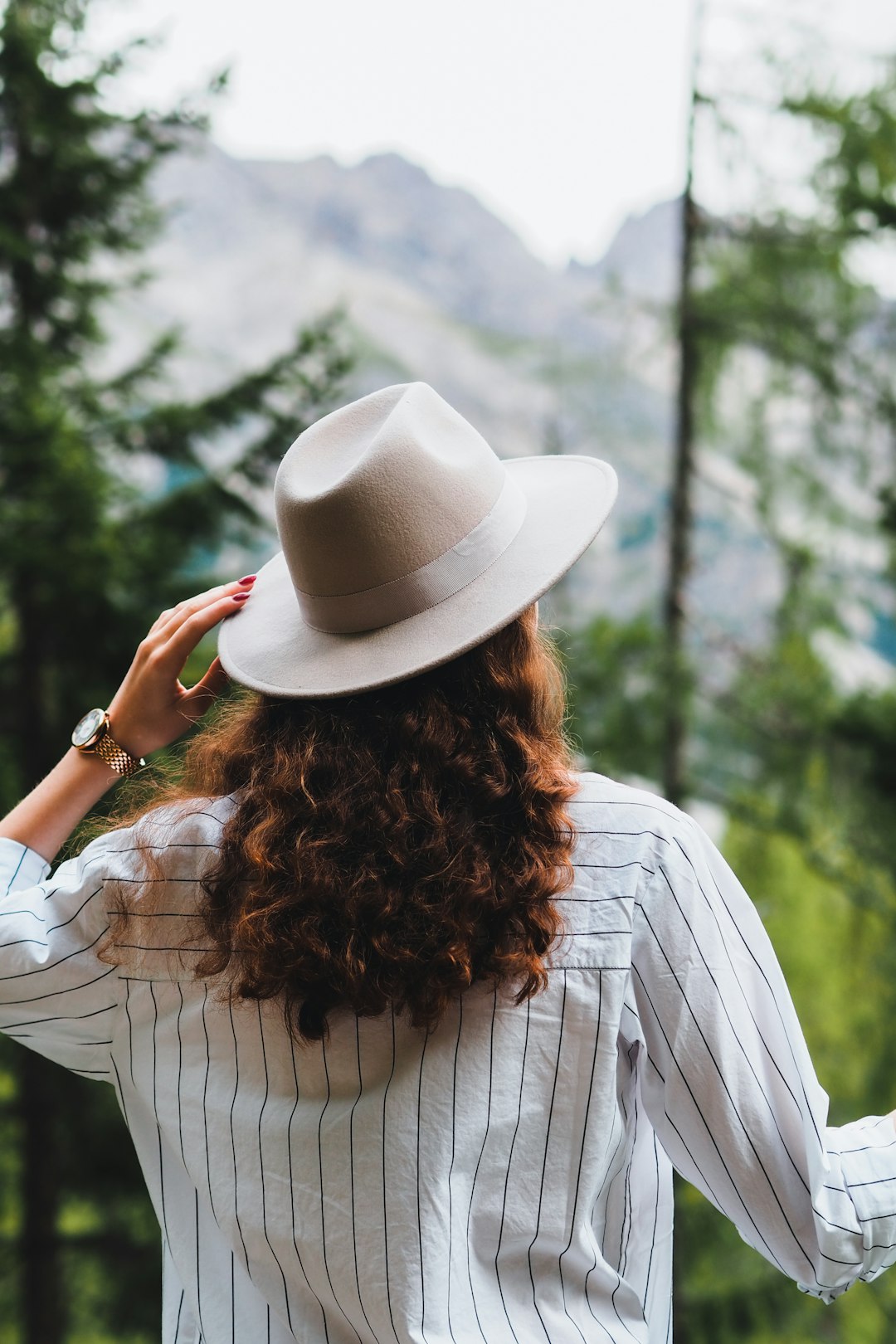 woman in white and black stripe shirt and white fedora hat