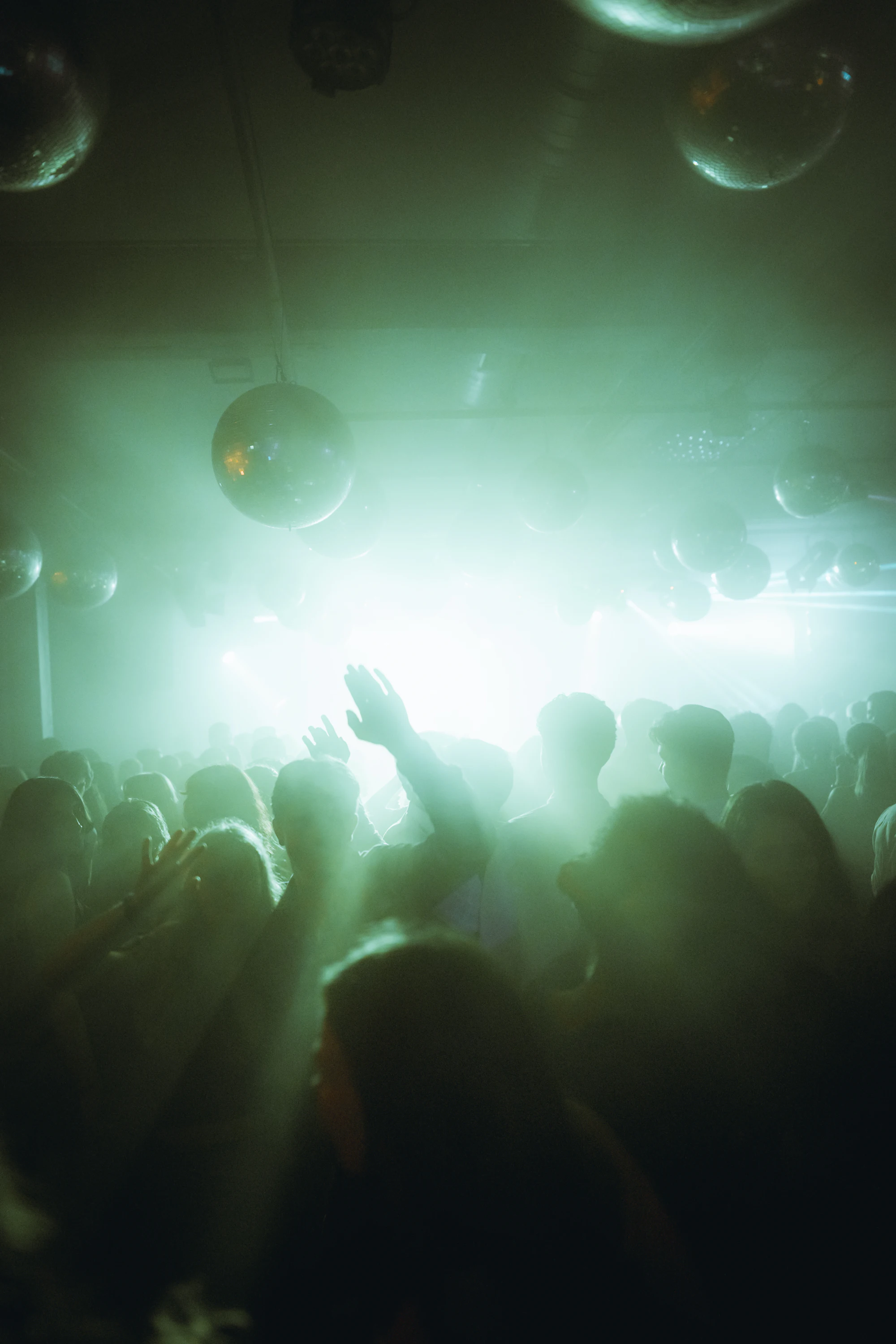 Silhouettes of a crowd with hands raised at a night out