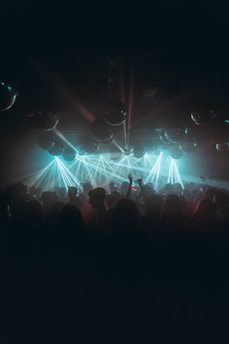 An inviting dance floor space lit with colorful lights and people dancing.