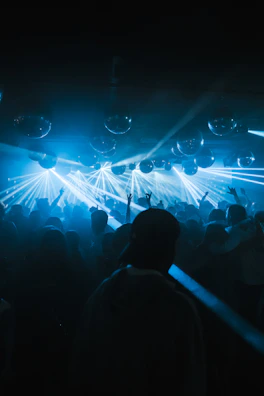 Wide shot of a packed dance floor at a premium wedding, glowing with neon accents and dynamic lighting.