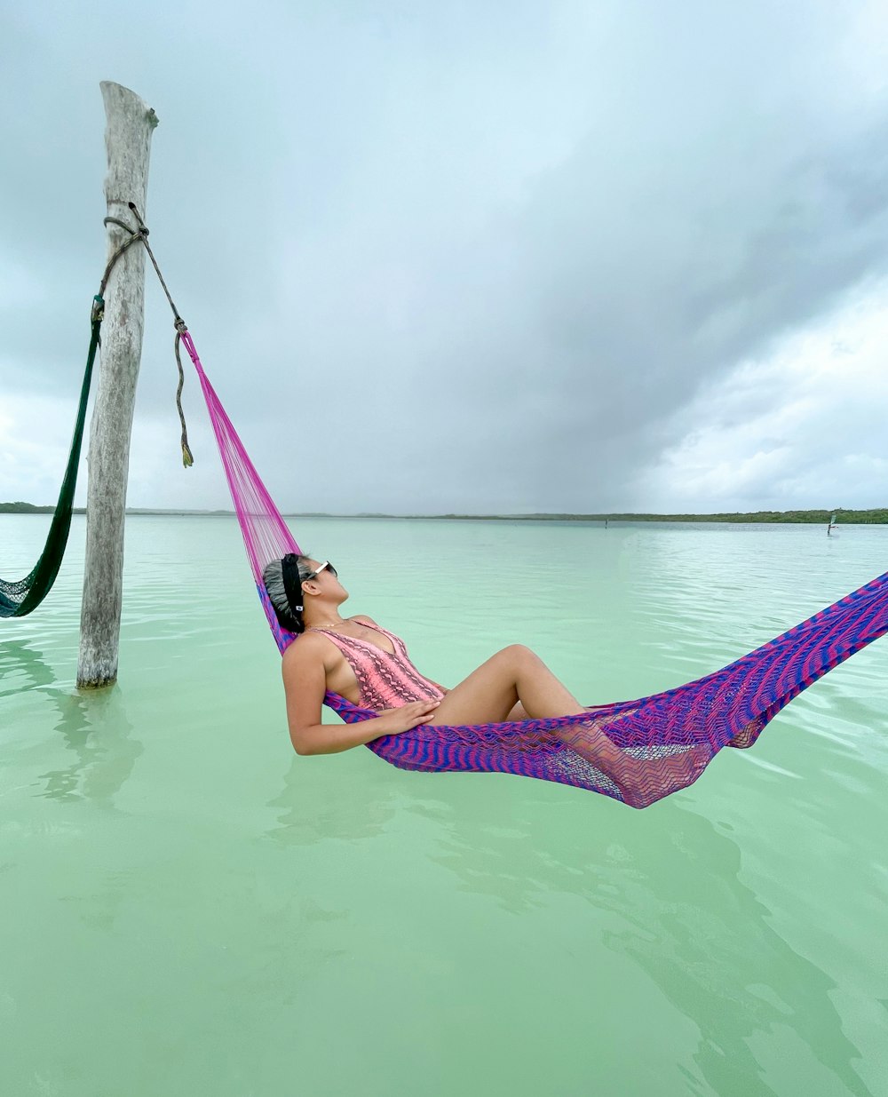 woman in pink bikini lying on hammock