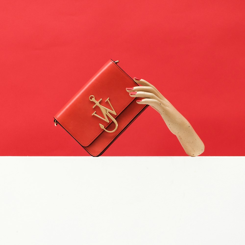 person holding pink leather wallet