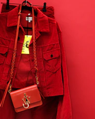 Vintage-inspired mustard yellow jacket displayed against a soft cream backdrop with bold ruby red accents.
