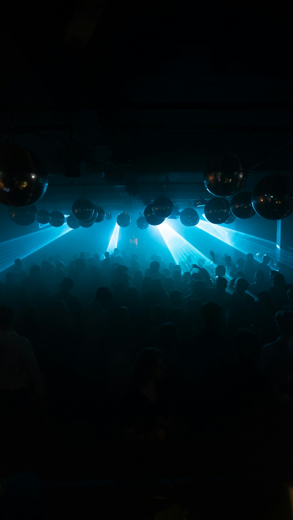 a group of people in a dark room with balloons