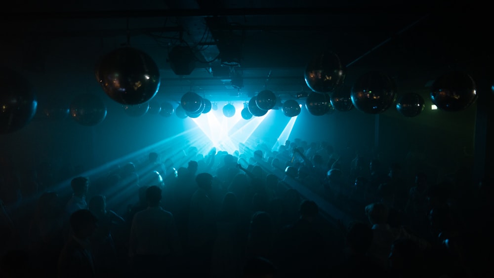 silhouette of people standing in front of blue light