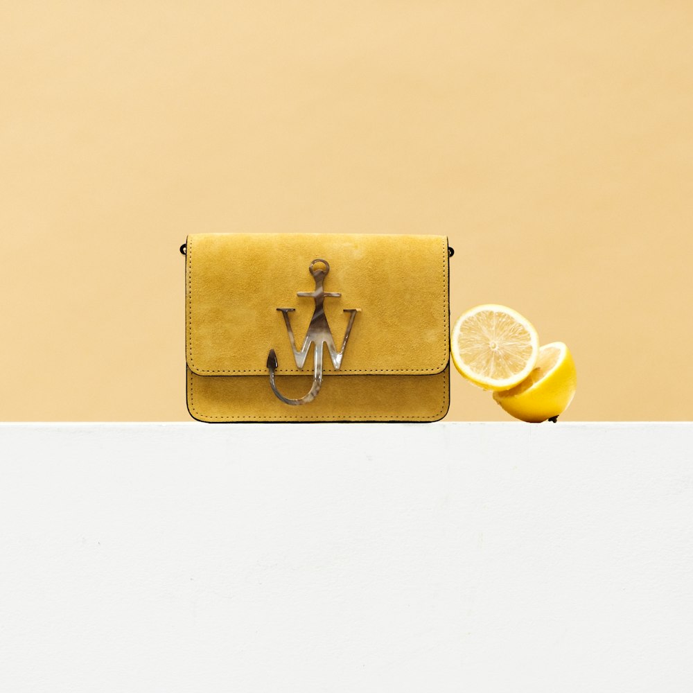 gold leather long wallet with yellow lemon and yellow round fruit