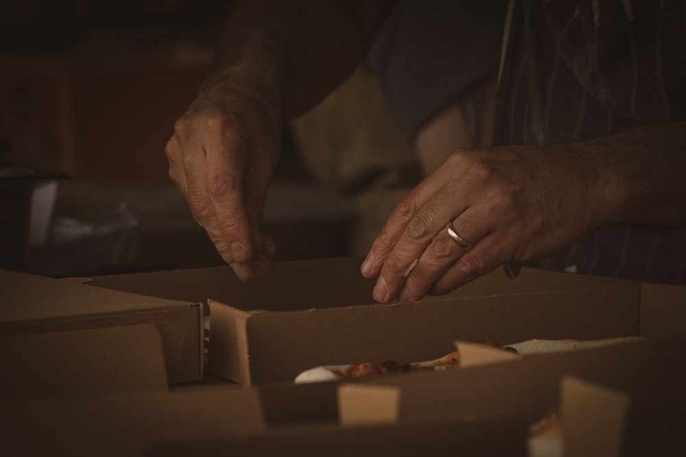 person in silver ring holding brown wooden chopping board