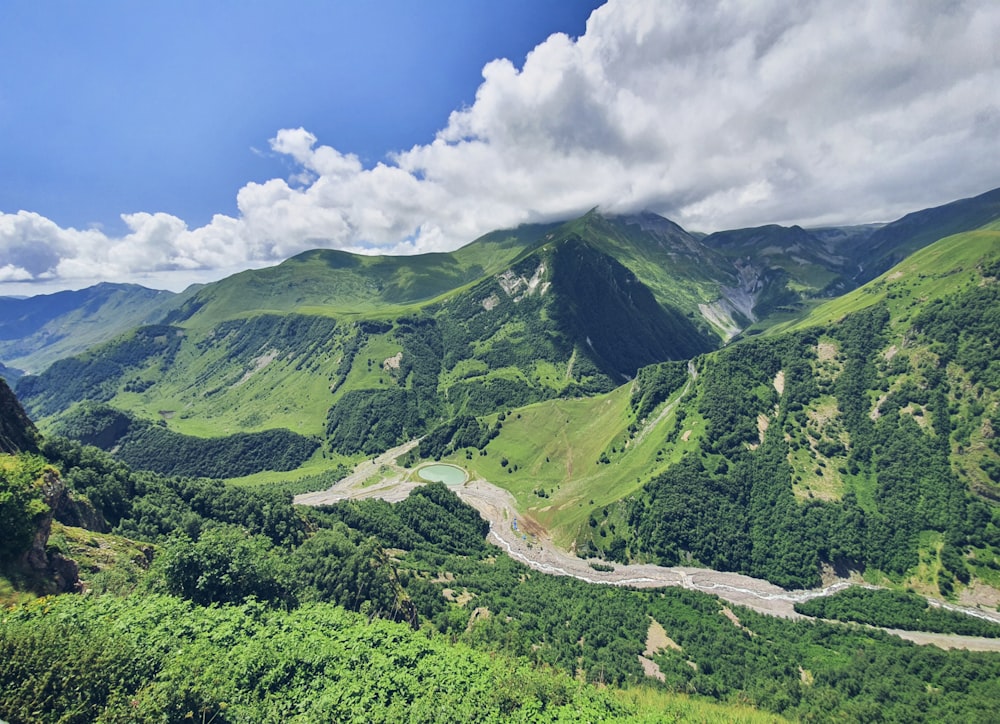 green mountains under blue sky and white clouds during daytime