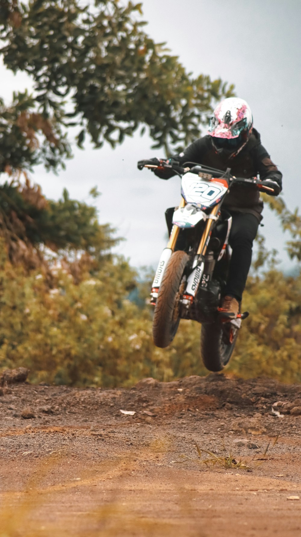 homme en casque noir conduisant une moto blanche et noire