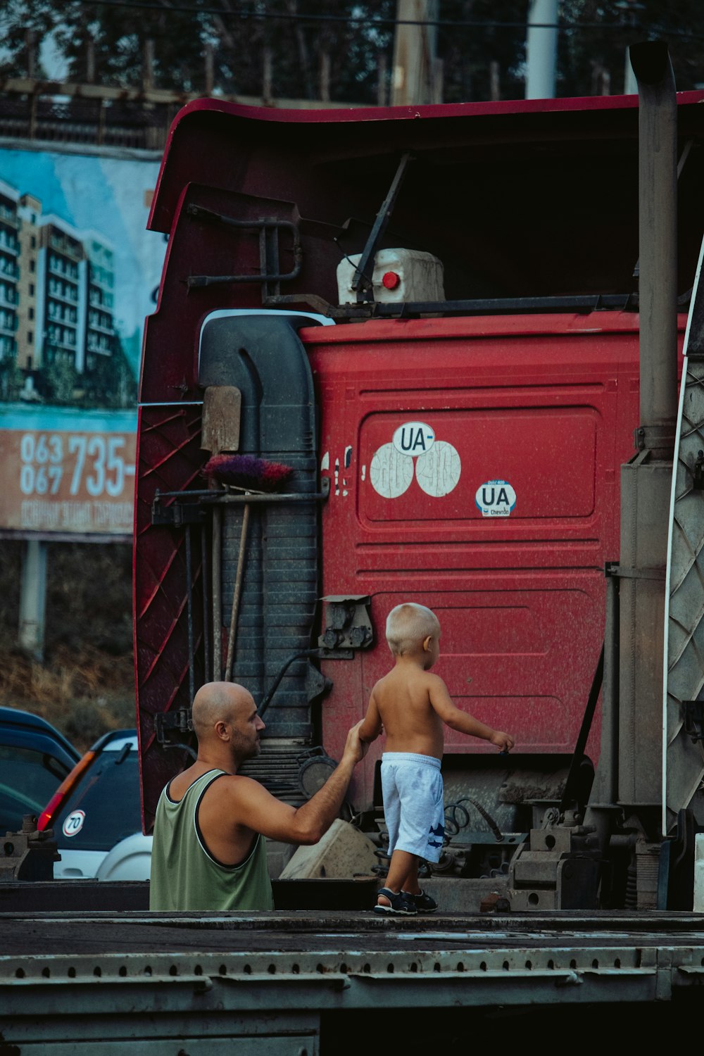 Junge im weißen Tanktop sitzt auf rotem LKW