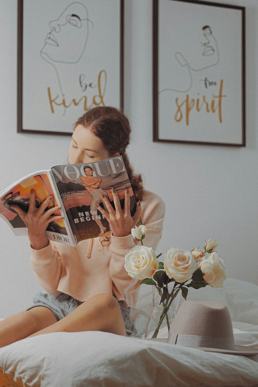 woman in white tank top holding book