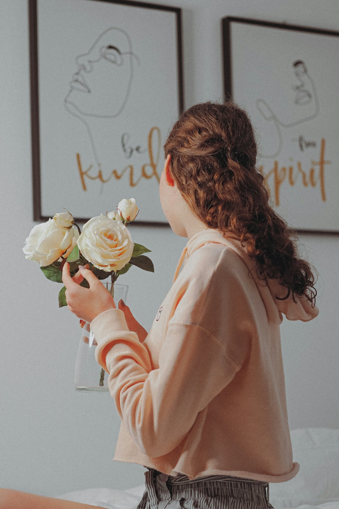 woman in pink long sleeve shirt holding white rose bouquet