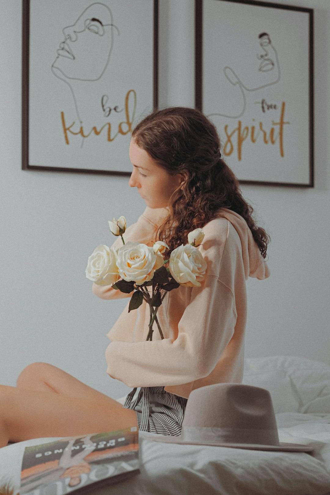 woman in pink long sleeve shirt holding white rose