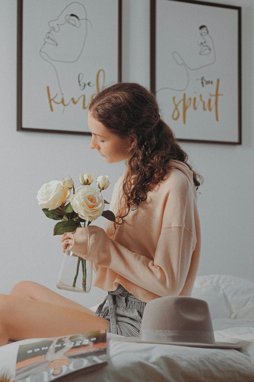 woman in pink long sleeve shirt holding white rose