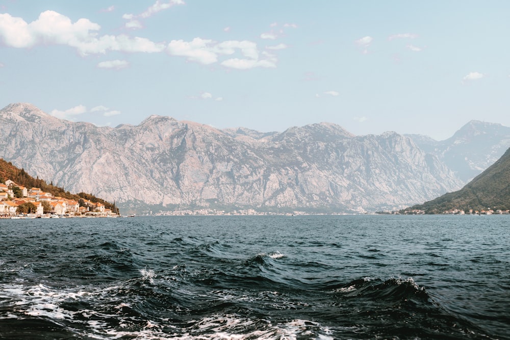 body of water near mountain during daytime