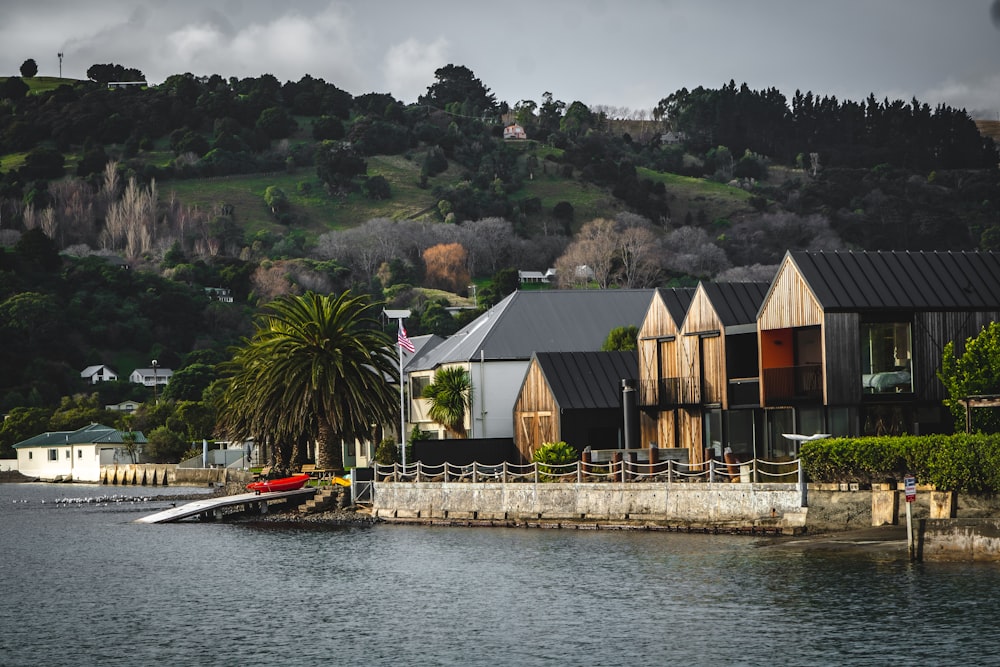 brown and white wooden house near body of water during daytime