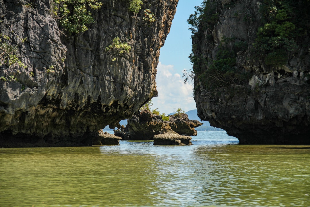 brown rock formation on body of water during daytime