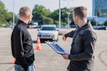 man in black jacket holding blue tablet computer