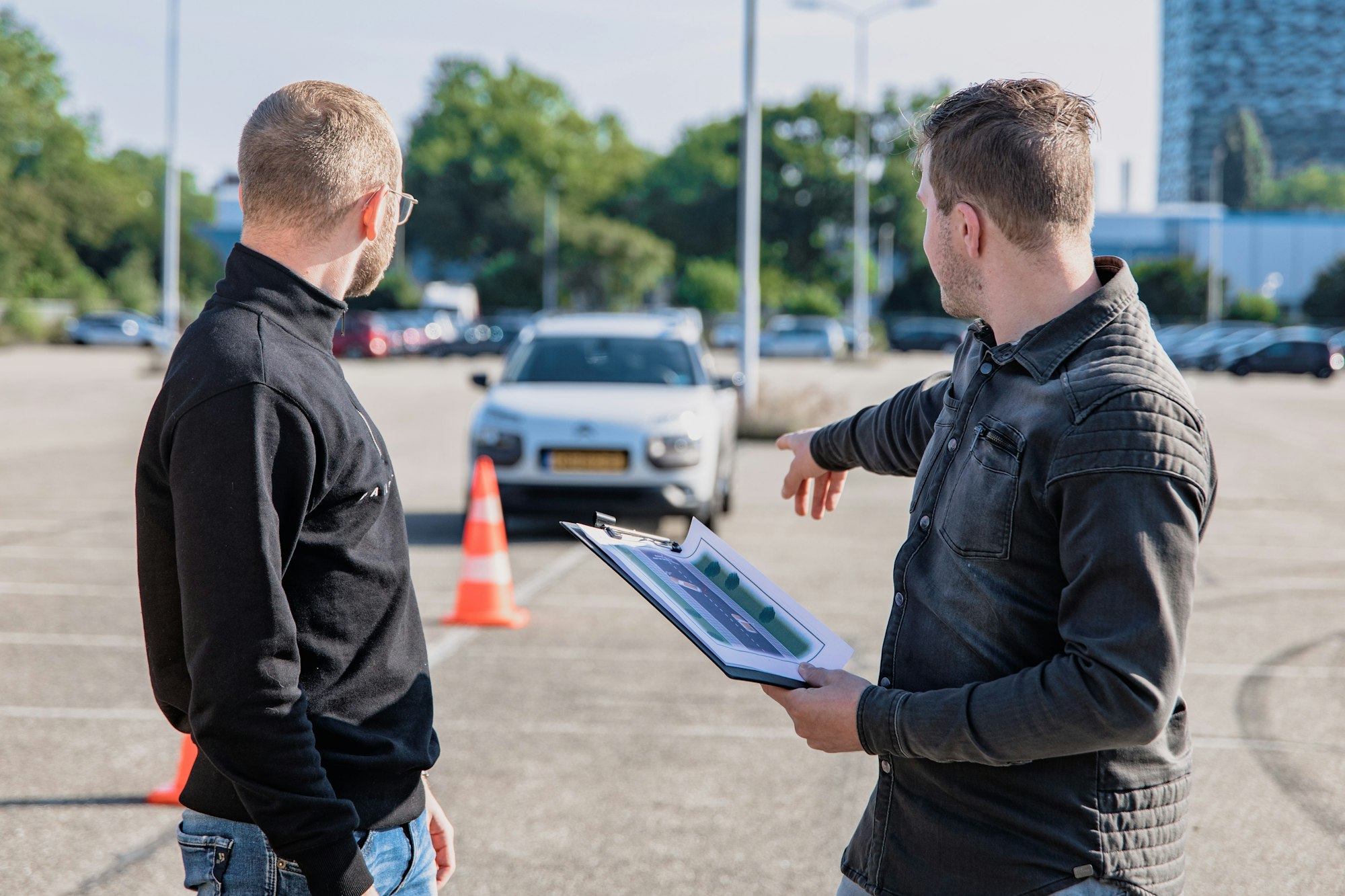 Driving instructor explaining to a student with trafic cone